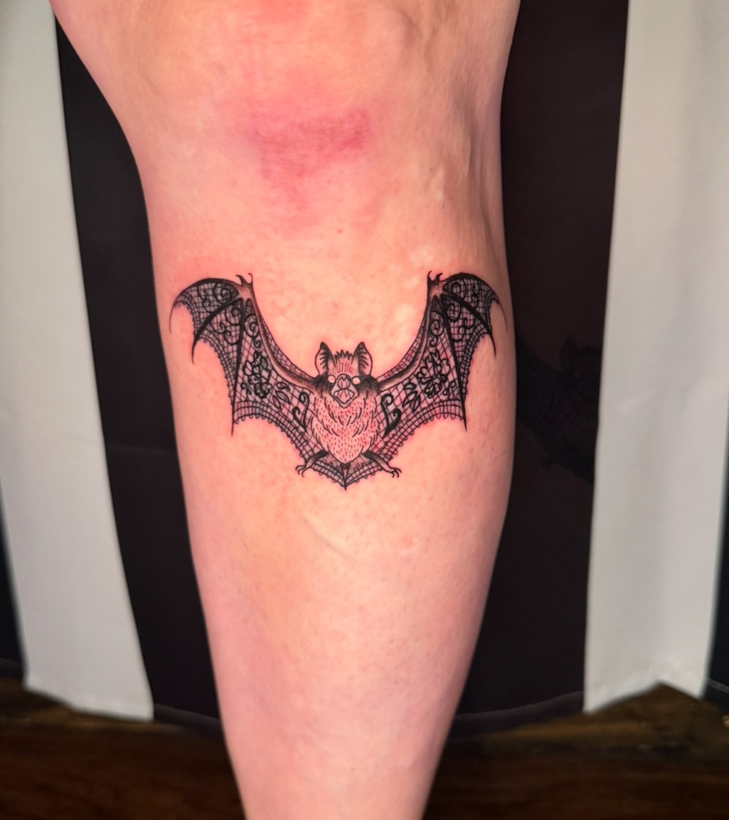 Detailed bat tattoo on leg, black and grey